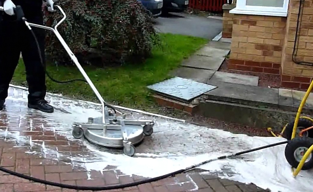 A Technician Pressure Washing a Walkway